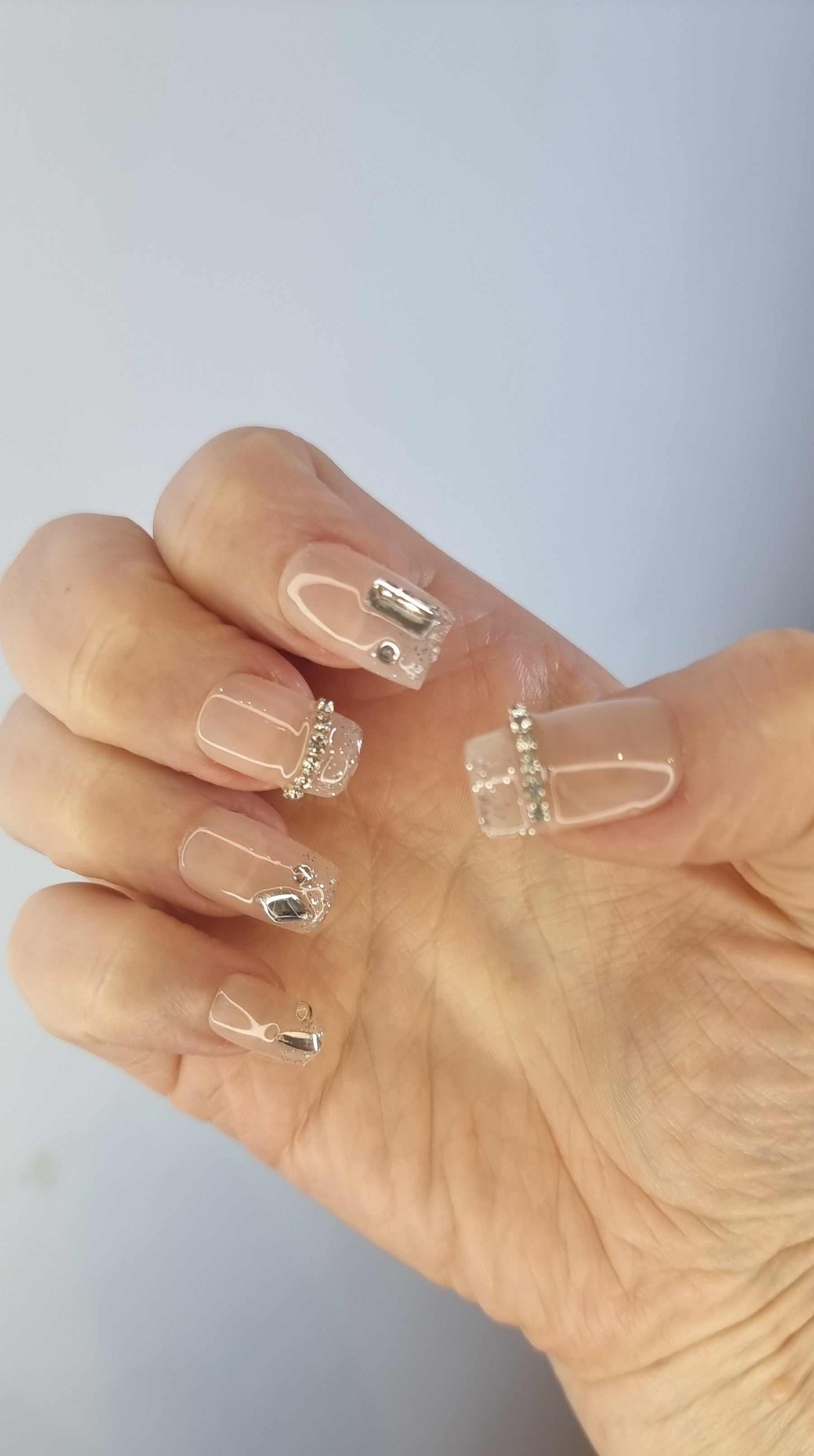 Transparent Ayisa press-on nails with silver embellishments for an elegant and trendy look