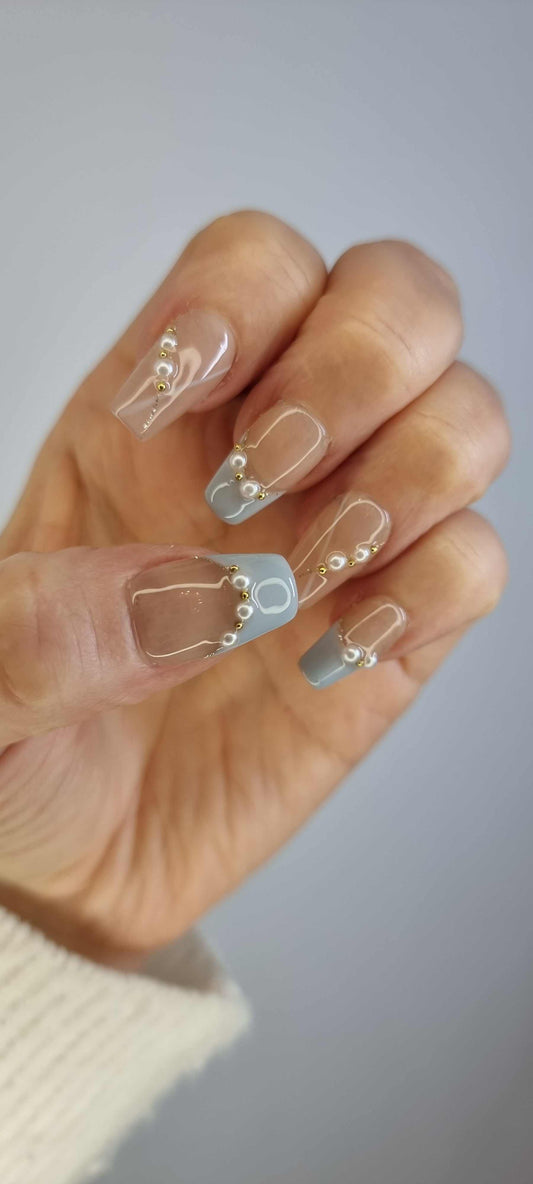 A model's hand wearing the chic Fadwa blue French press-on nails.