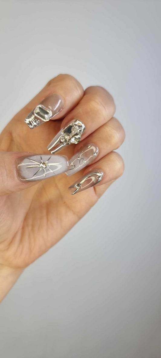 A model's hand wearing the avant-garde Habibi press-on nails, showcasing the unique 3D sculpted details.
