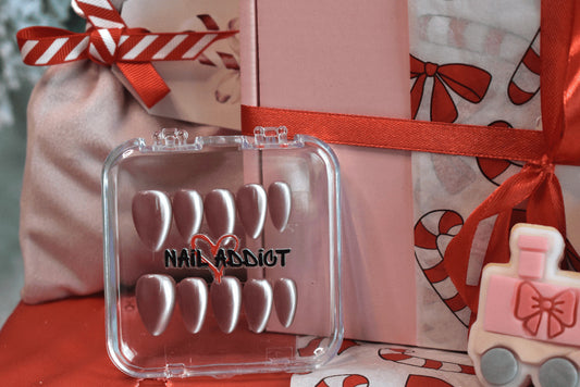 Nail art display with 'Nail Addict' branding in front of a festive gift bag.