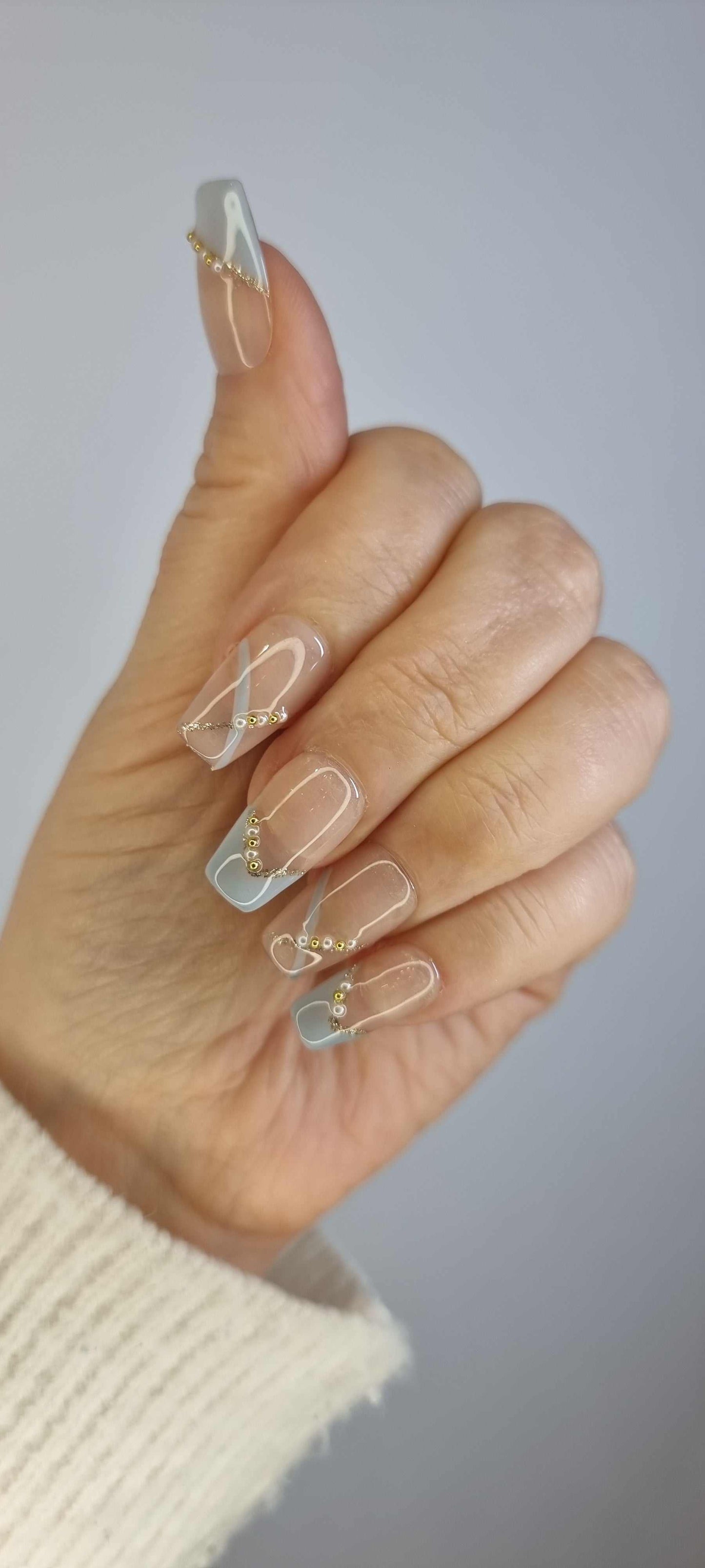 Set of Ranya translucent press-on nails with a subtle sparkle or gem detail.