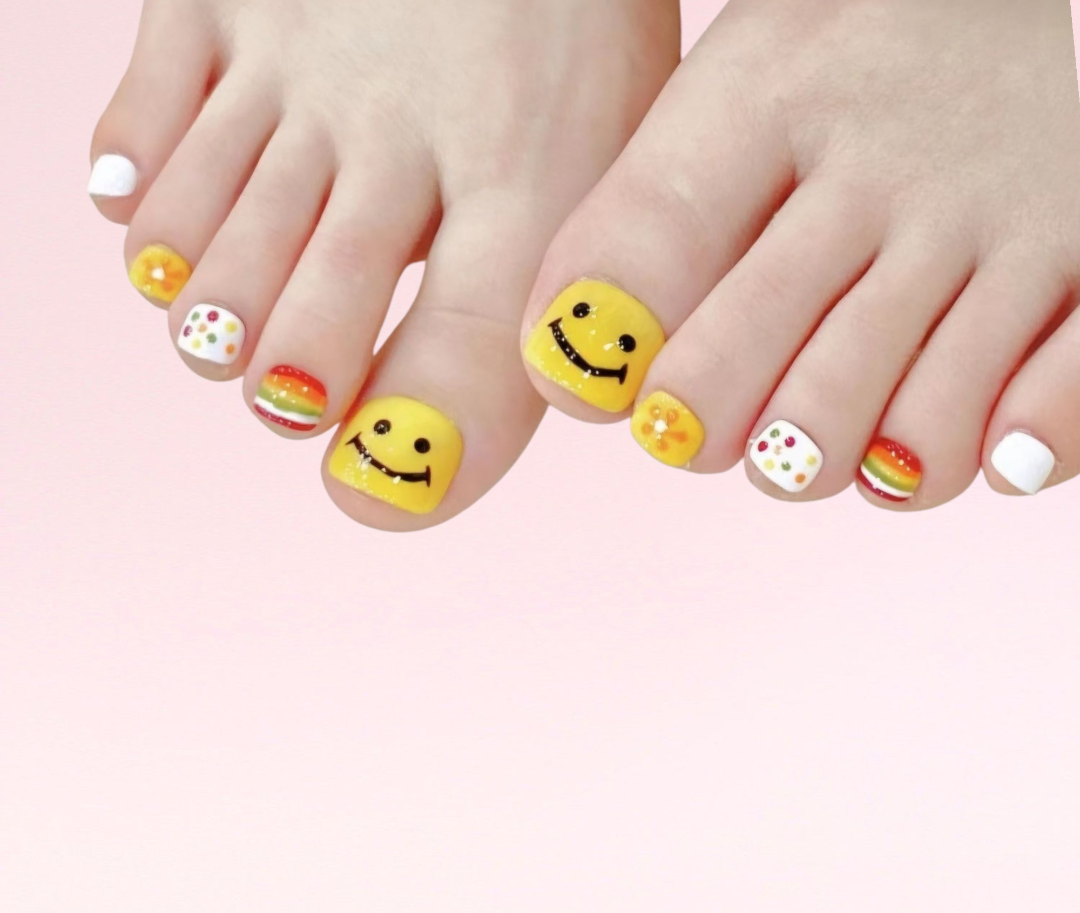 Close-up of feet featuring Saadiyat multi-color press-on toe nails, various designs.