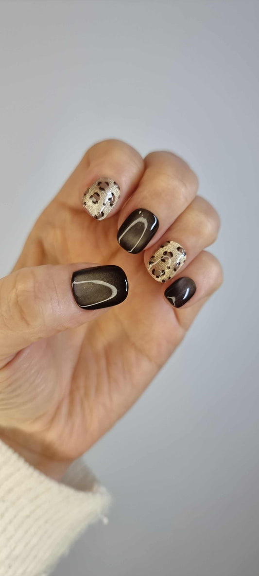 A set of false press-on nails with an animal print design. The nails alternate between a solid glossy brown color and a beige leopard spot pattern
