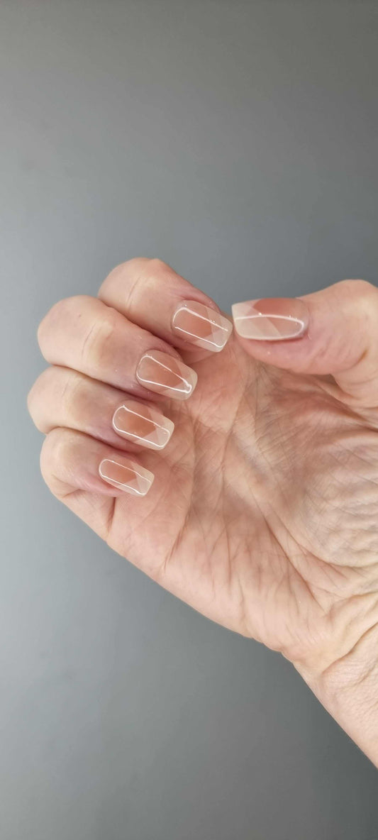 A set of nude and light brown artificial nails. The design features a translucent geometric pattern with light-catching lines for a crystal effect.