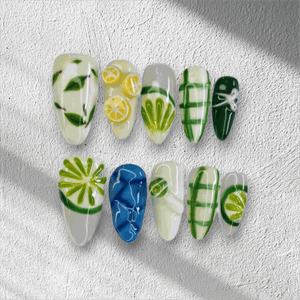 The Al Ain Allure press-on nail set in a long almond shape, featuring intricate 3D citrus and leaf art on a mix of white, green, and blue nails.