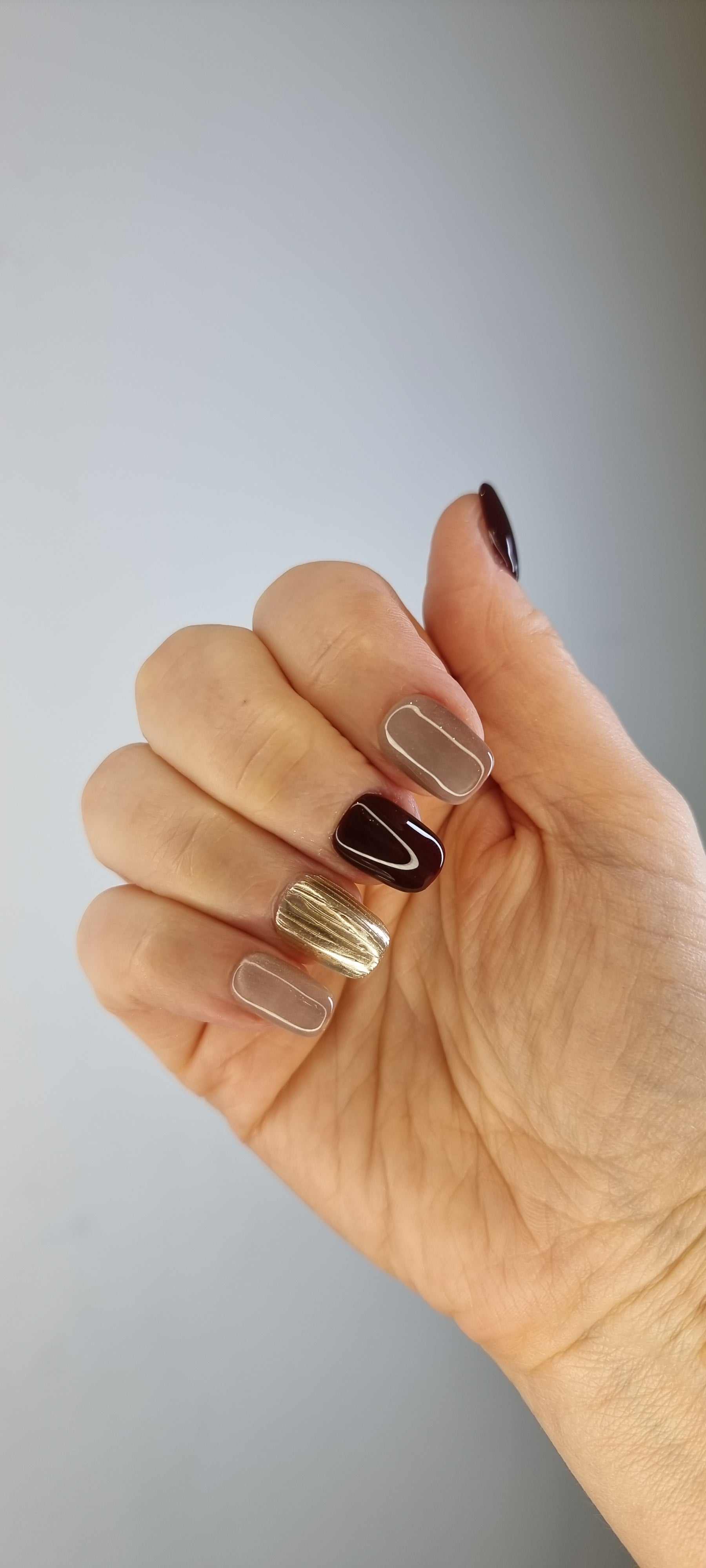 A close-up of the Al Khobar Chic manicure, highlighting the luxurious textured gold accent nail on the short square press-ons.