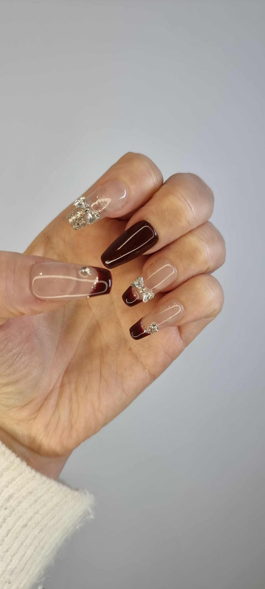 Hand wearing Amira long coffin press-on nails, showcasing the iridescent silver swirls on a glossy pink base.