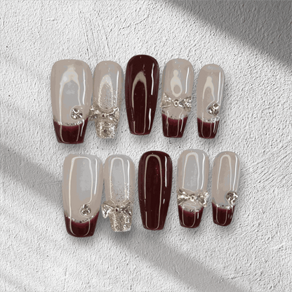 Amira sheer pink and silver long coffin press-on nails by Nail Addict, with a liquid chrome effect and delicate charms.