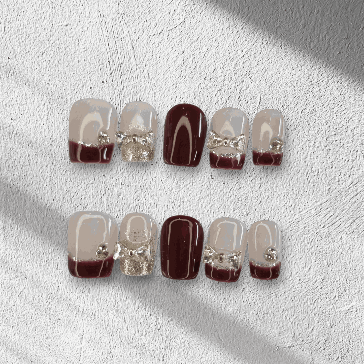 Amira sheer pink and silver short coffin press-on nails by Nail Addict, with a liquid chrome effect and delicate charms.