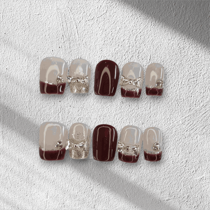 Amira sheer pink and silver short coffin press-on nails by Nail Addict, with a liquid chrome effect and delicate charms.