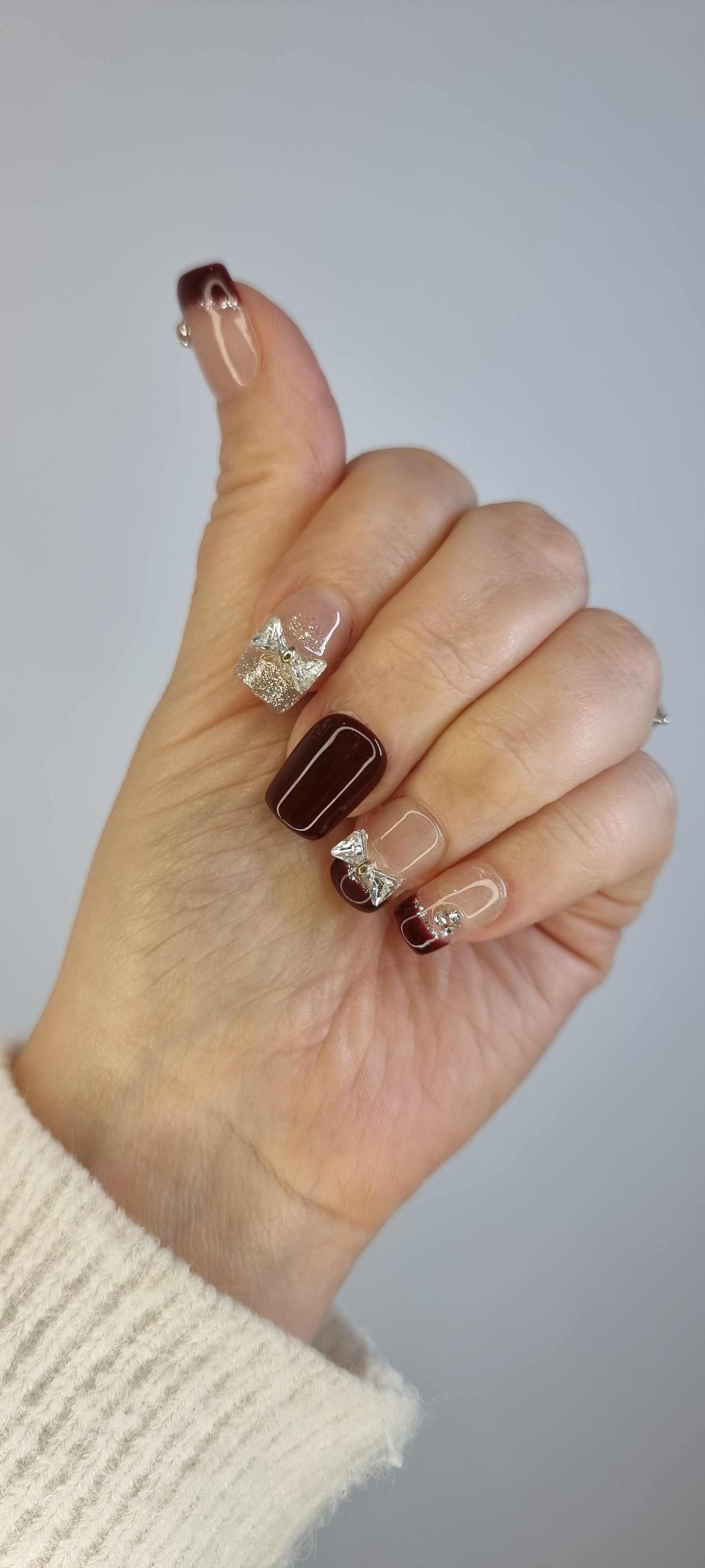 Close-up of Amira short press-on nail, highlighting the unique liquid chrome pattern and sparkling jewel embellishments.