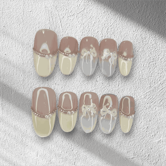 The Aseel press-on nail set in a medium round shape, featuring a classic French manicure design with 3D white bows and pearl details.