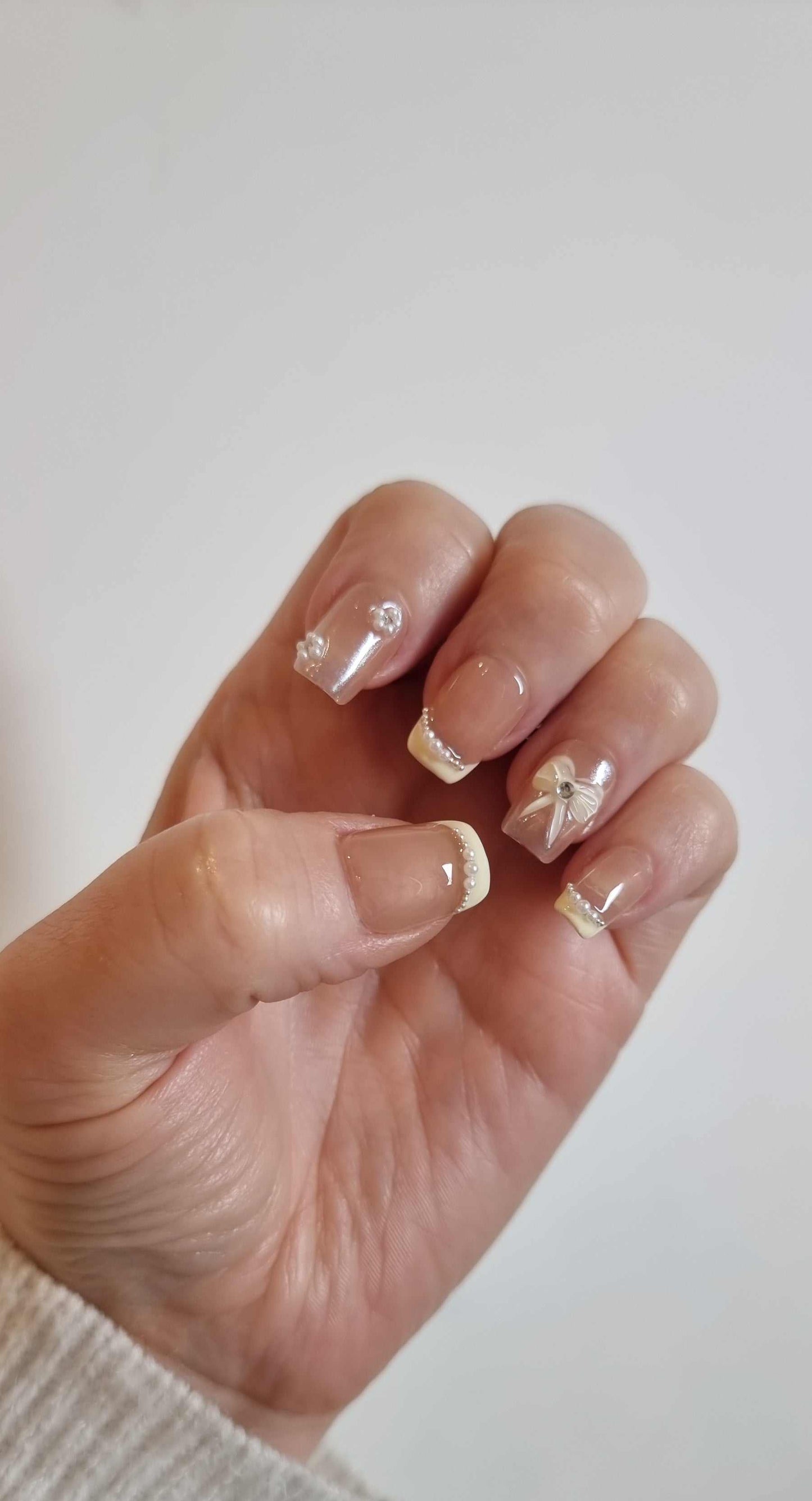 A close-up of the Bahrain Bliss manicure, highlighting the sophisticated bridal design on the short square press-on nails.