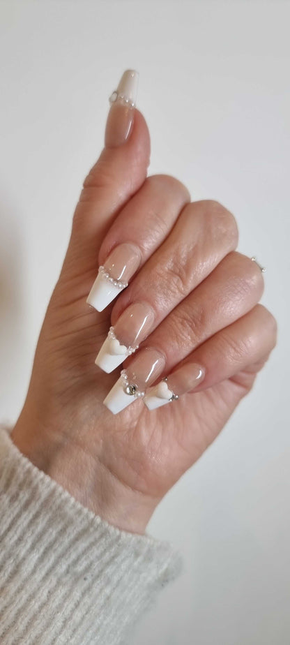 Close-up of a model's hand wearing the Burj Beauty French manicure press-on nails