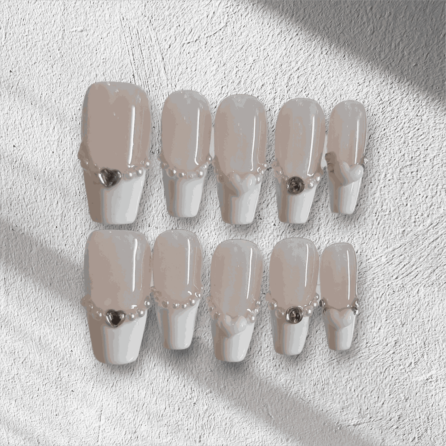 The Burj Beauty press-on nail set in a short square French manicure style.