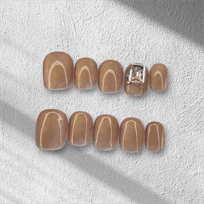 The Bushra press-on nail set in a short squoval shape, displayed in the box.