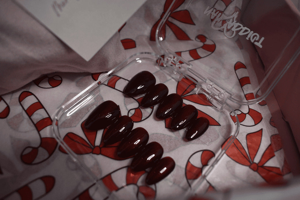Brown nail polish bottles in a clear case on a candy-themed background