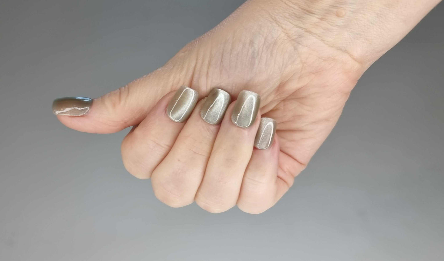 A close-up of the Dammam Delight manicure, highlighting the glossy finish and pearlescent cat-eye effect on the short square nails.