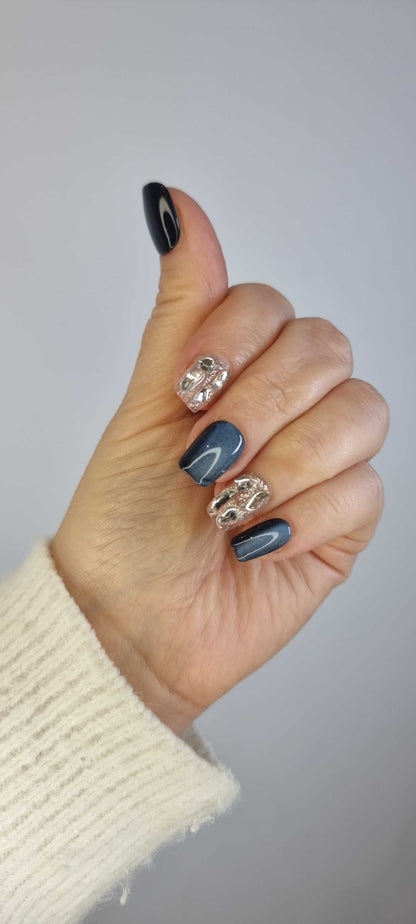 A close-up of the Days in Dubai manicure, highlighting the sophisticated grey-blue color and molten chrome effect on the short square nails.