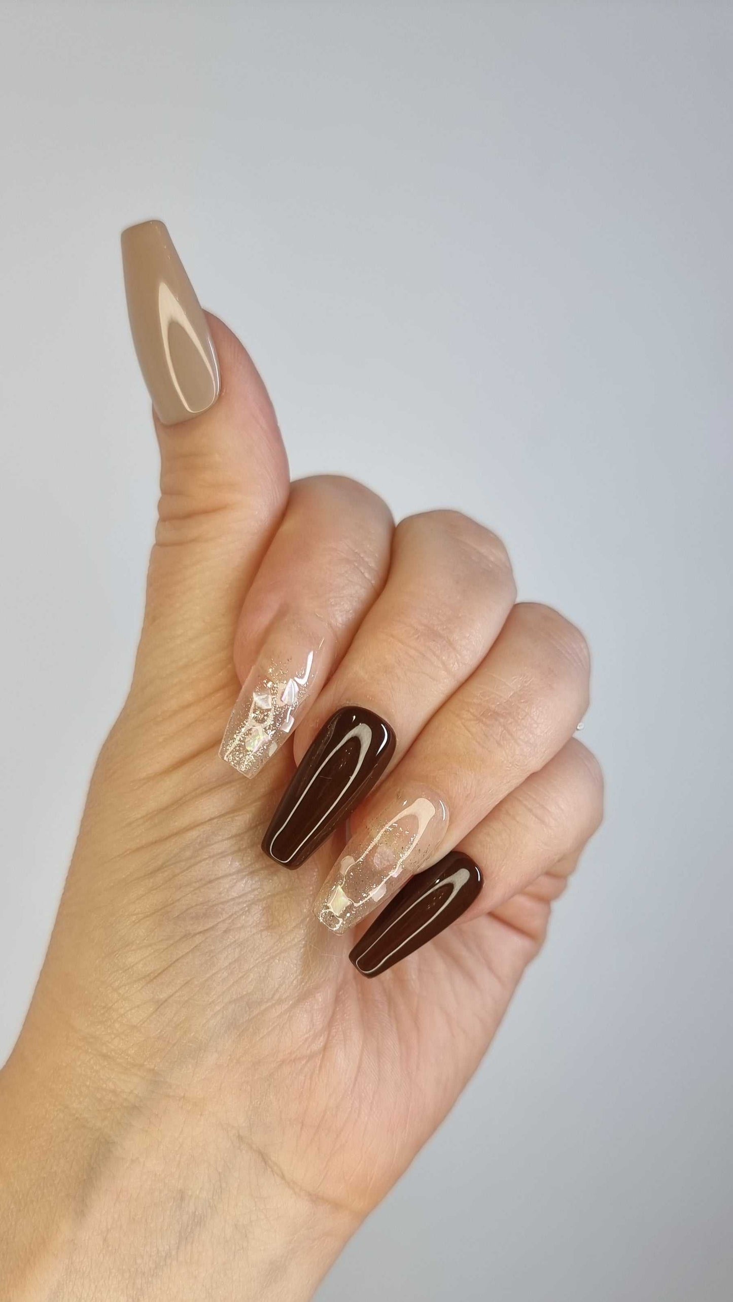 A close-up of the Desert Crush manicure, highlighting the glossy finish and sophisticated color palette of the coffin-shaped press-on nails.