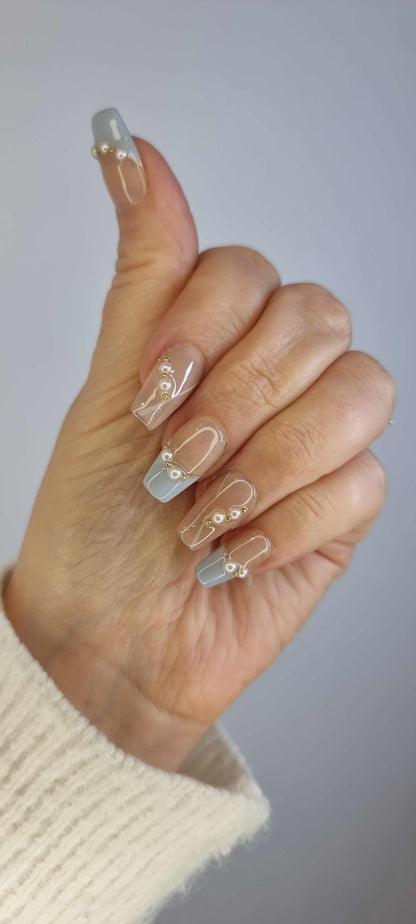 Close-up of the Fadwa manicure, on a model's hand highlighting the chic blue French tip design.