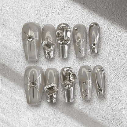 The Habibi press-on nail set in a long coffin shape, featuring intricate 3D sculpted faces and art on a semi-transparent base.