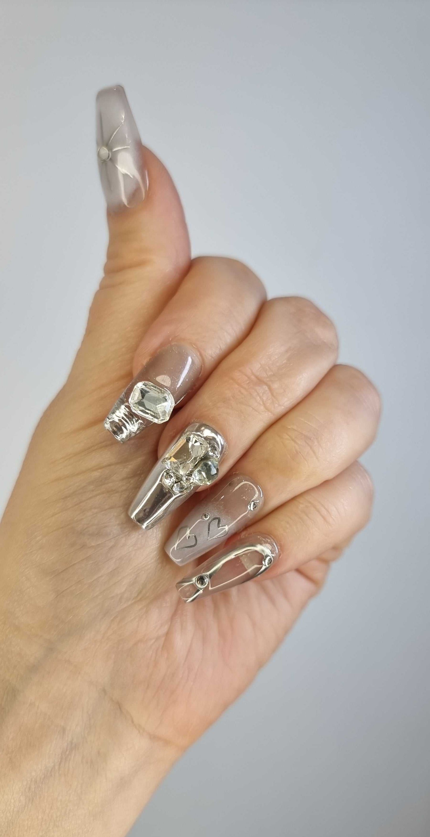 A close-up of the Habibi long coffin press-on manicure, highlighting the artistic, three-dimensional sculpted designs.