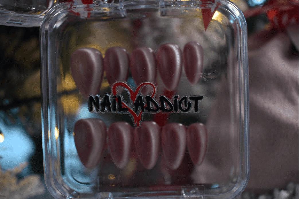 Clear case with pink nail tips and 'Nail Addict' branding.