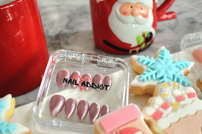 Nail art display with 'Nail Addict' branding next to Christmas-themed cookies and a Santa mug.