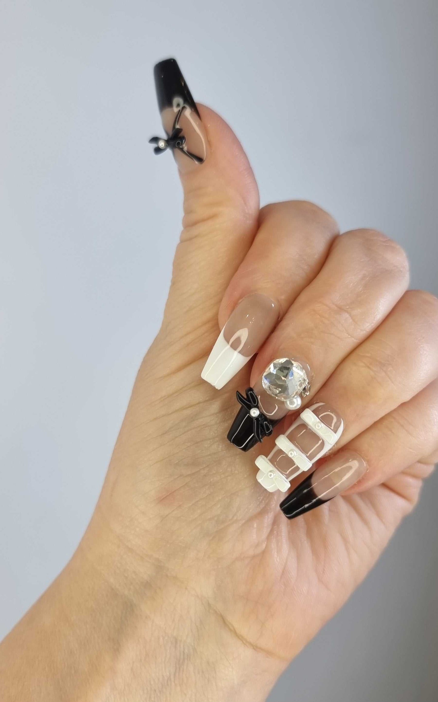 A close-up of the Hasaas press-on nail manicure, demonstrating the chic, high-fashion look of the 3D bows.