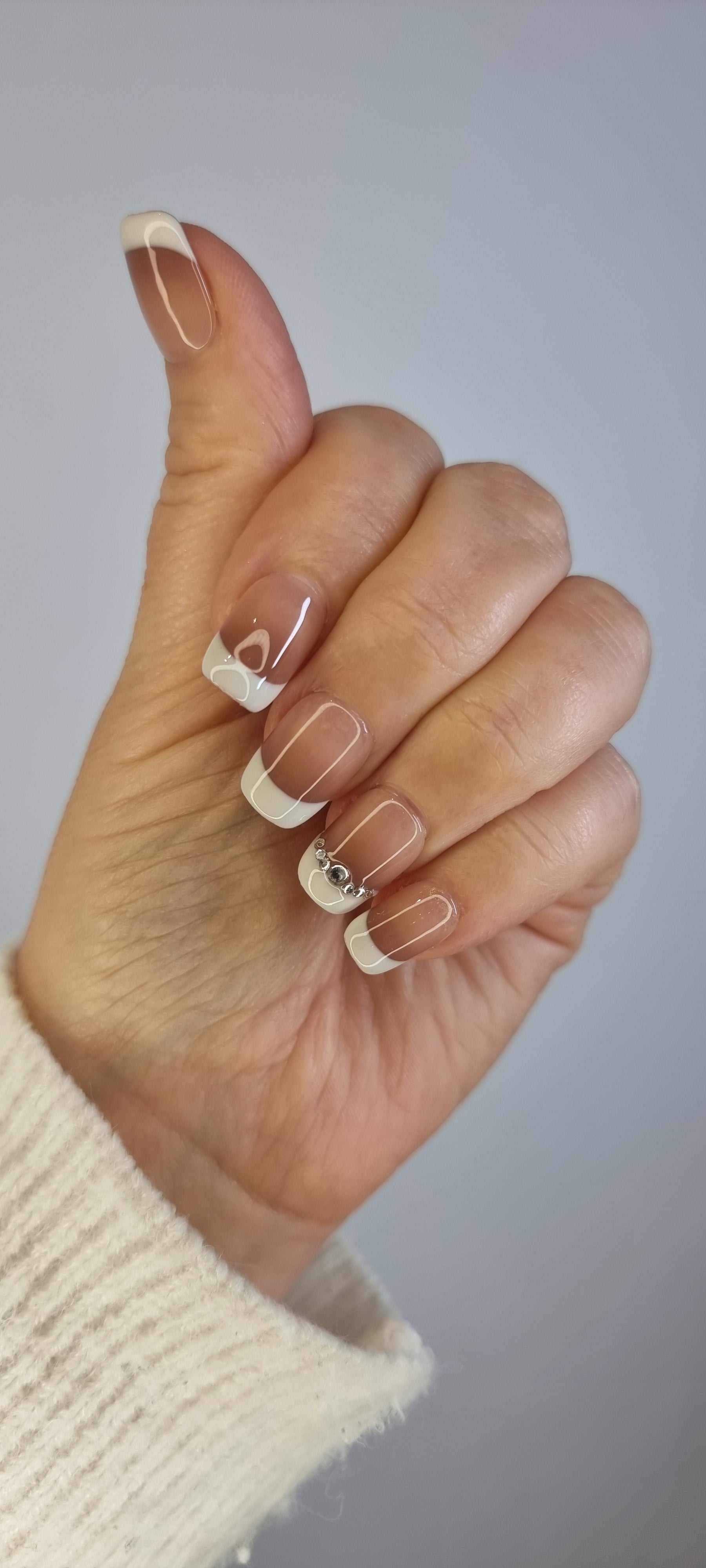 Hand wearing Hues of Hatta press-on nails by Nail Addict, highlighting the two-toned design and the short square shape.