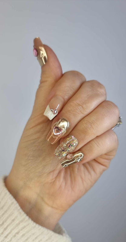  Hand wearing Jawhara Glow press-on nails by Nail Addict, showcasing the long coffin shape and elegant pearl and gold chain embellishments.