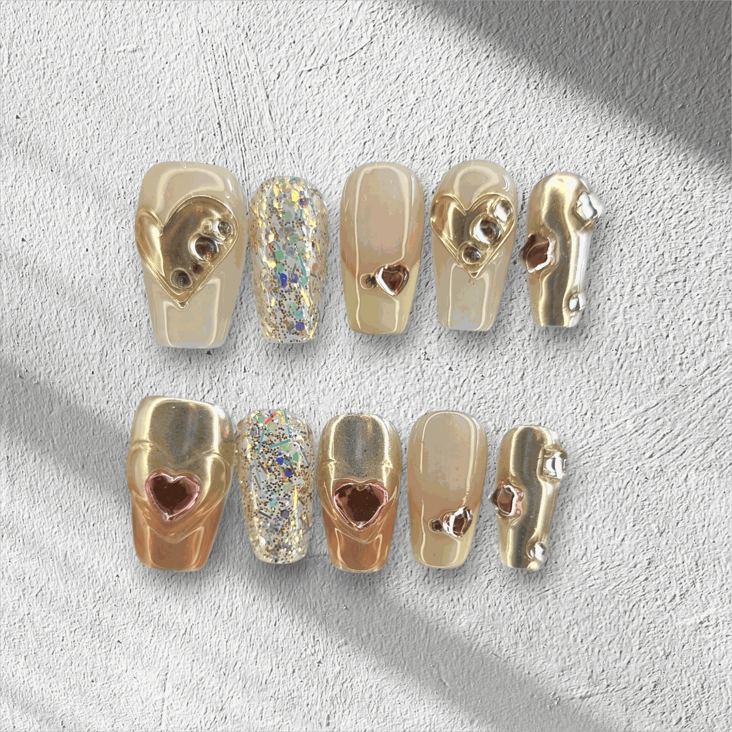 Jawhara Glow nude and brown long coffin press-on nails by Nail Addict, featuring 3D gold chain and pearl accents.