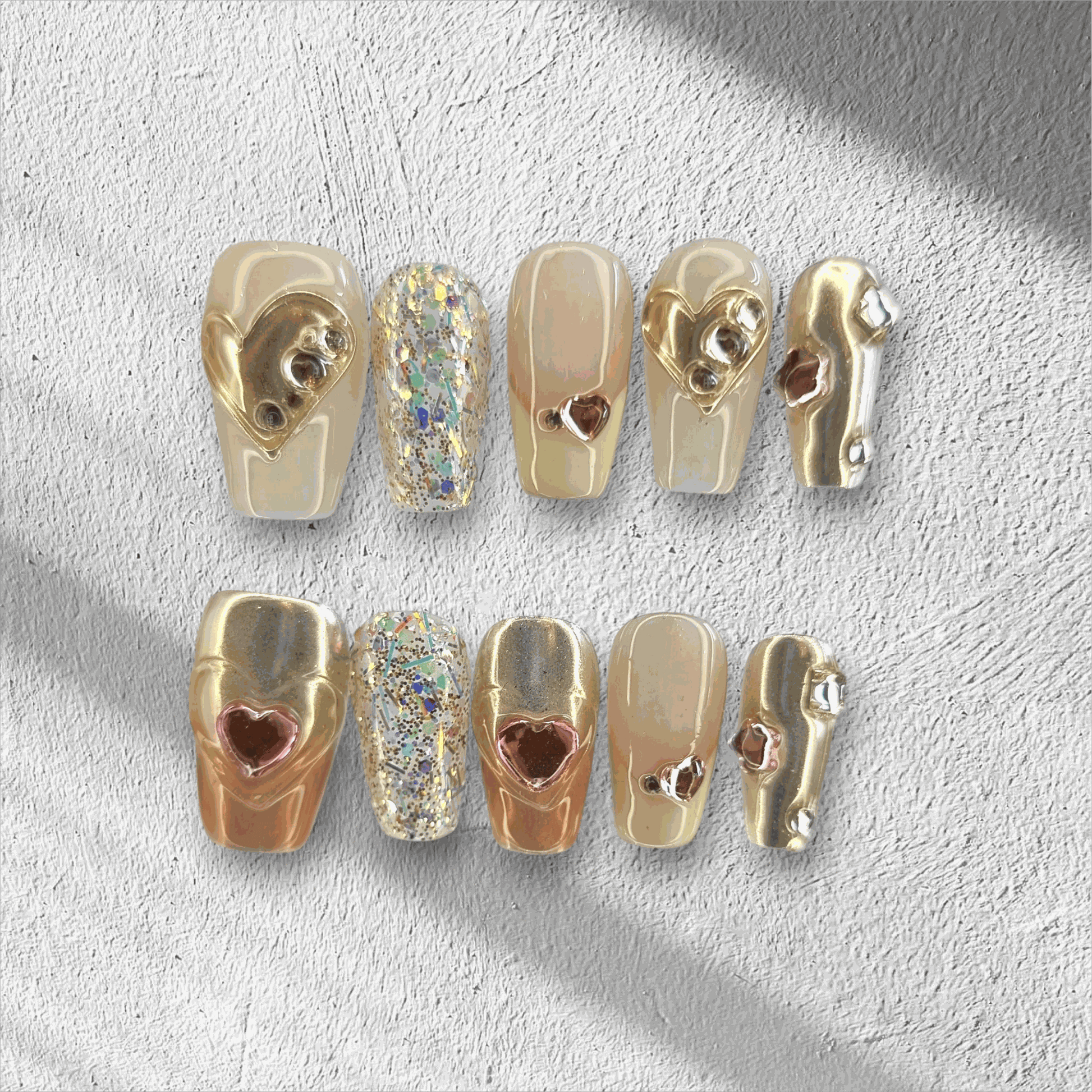 Jawhara Glow nude and brown long coffin press-on nails by Nail Addict, featuring 3D gold chain and pearl accents.