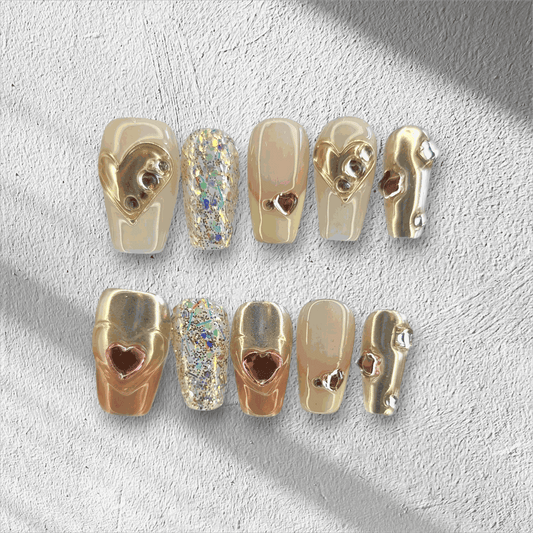 Jawhara Glow nude and brown long coffin press-on nails by Nail Addict, featuring 3D gold chain and pearl accents.