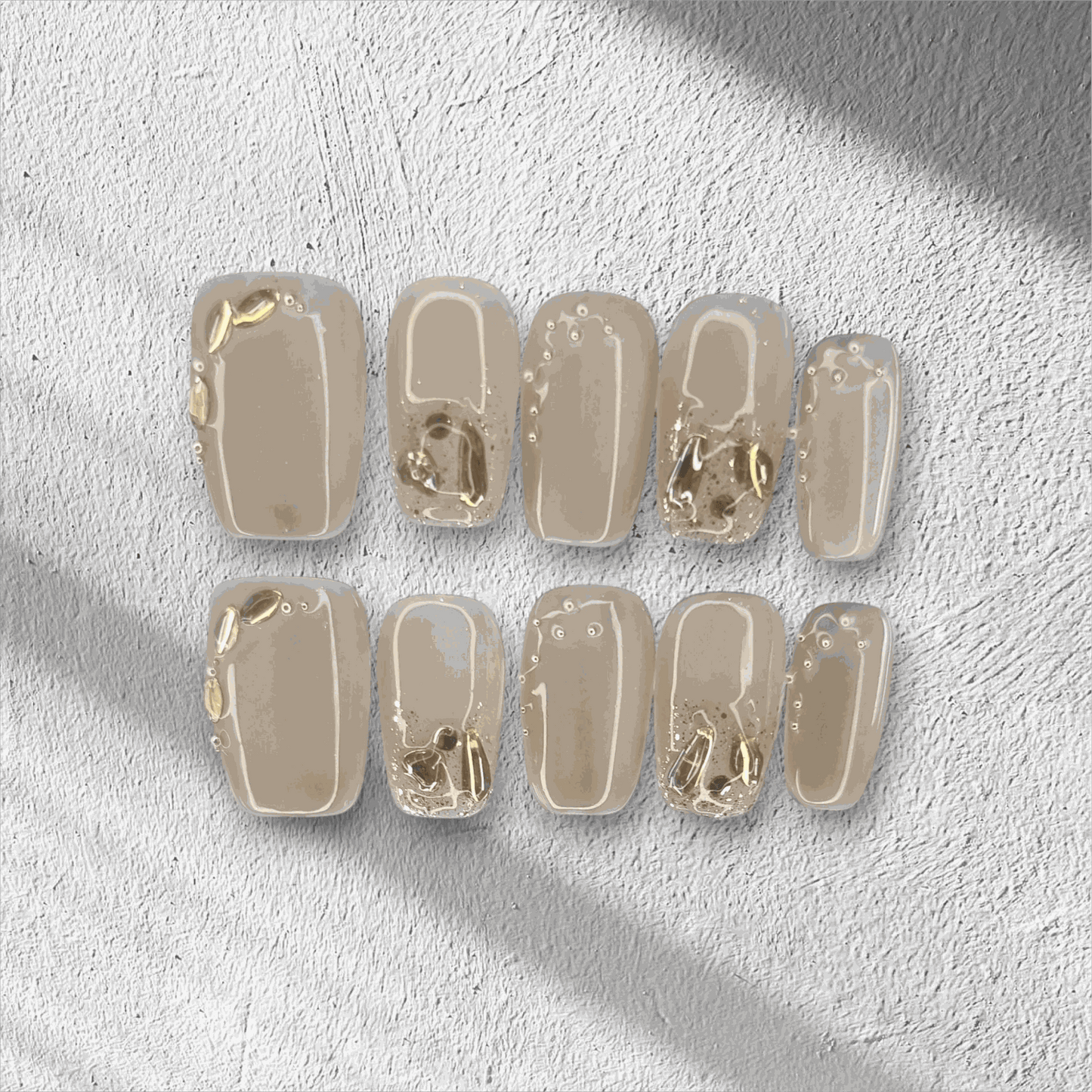 Joud nude short square press-on nails by Nail Addict, featuring silver liquid-effect accents.