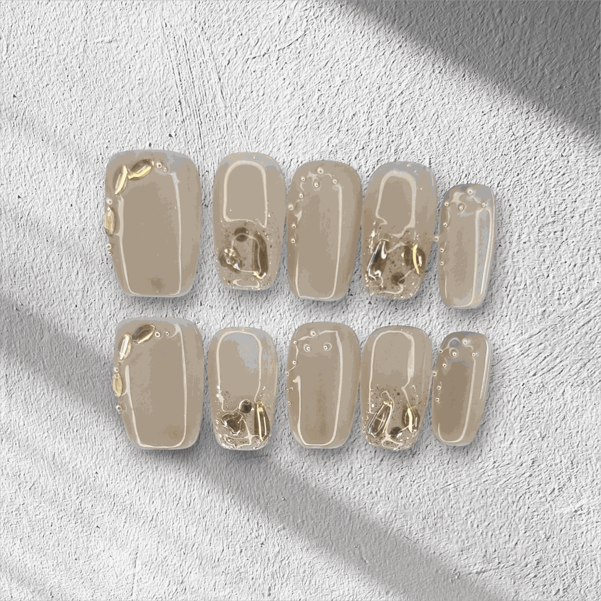 Joud nude short square press-on nails by Nail Addict, featuring silver liquid-effect accents.