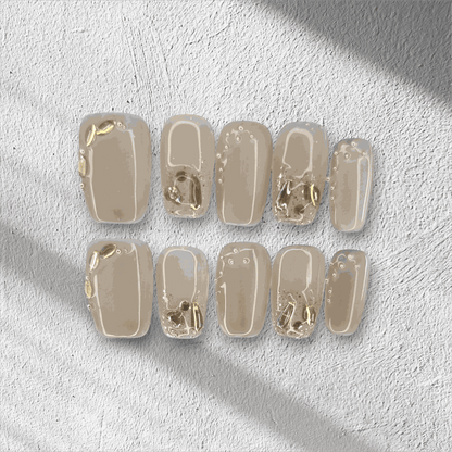 Joud nude short square press-on nails by Nail Addict, featuring silver liquid-effect accents.