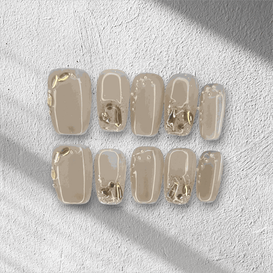 Joud nude short square press-on nails by Nail Addict, featuring silver liquid-effect accents.