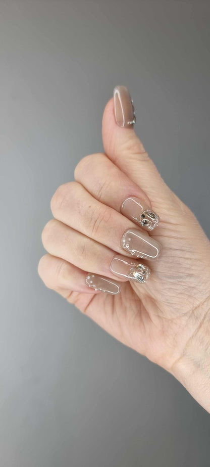  Hand wearing Joud press-on nails by Nail Addict, highlighting the unique liquid-effect design and short square shape.