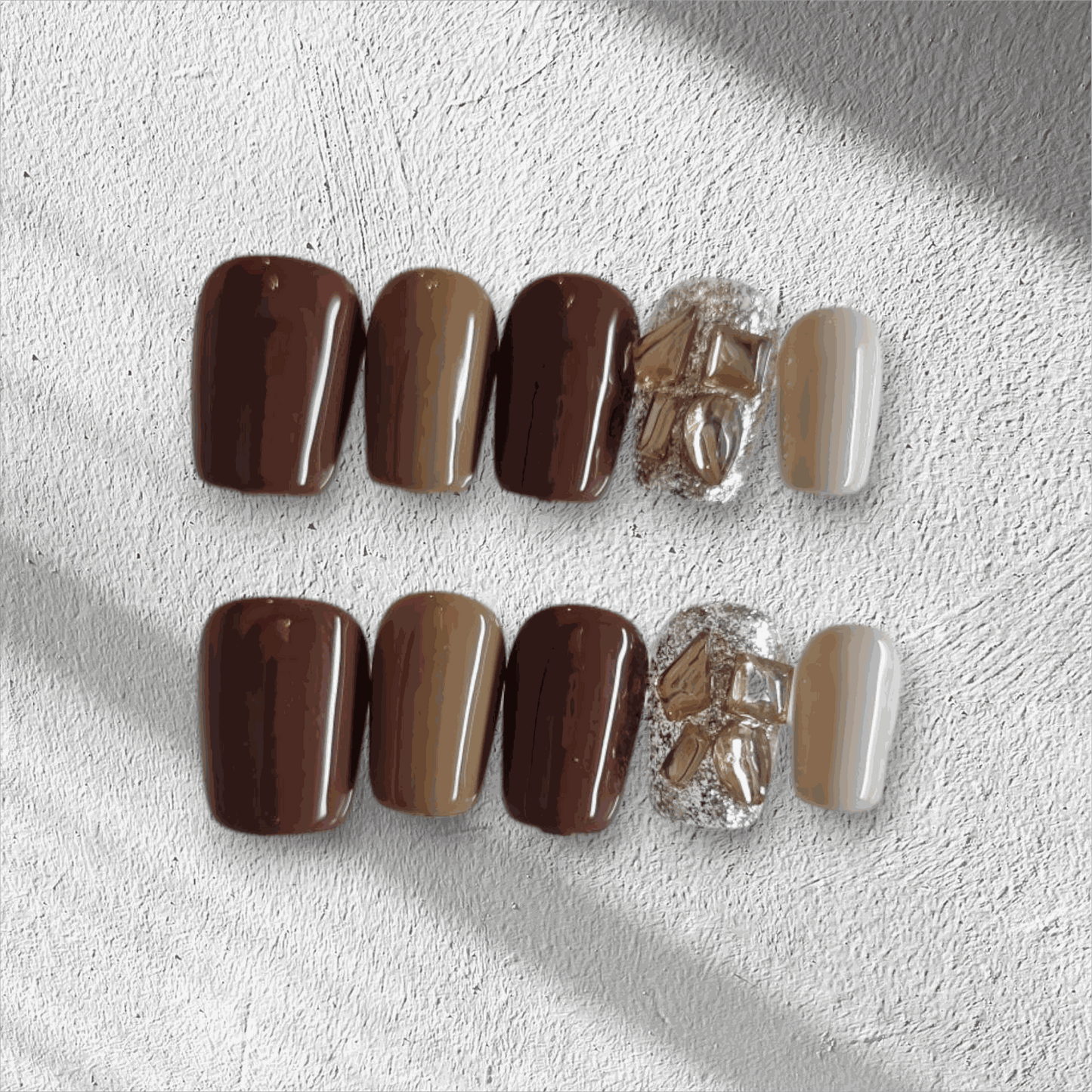Jumeirah Glow brown and nude short square press-on nails by Nail Addict, featuring a statement gold foil and rhinestone accent nail.