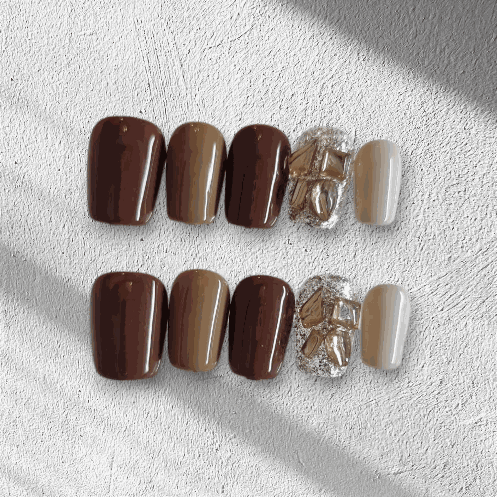 Jumeirah Glow brown and nude short square press-on nails by Nail Addict, featuring a statement gold foil and rhinestone accent nail.