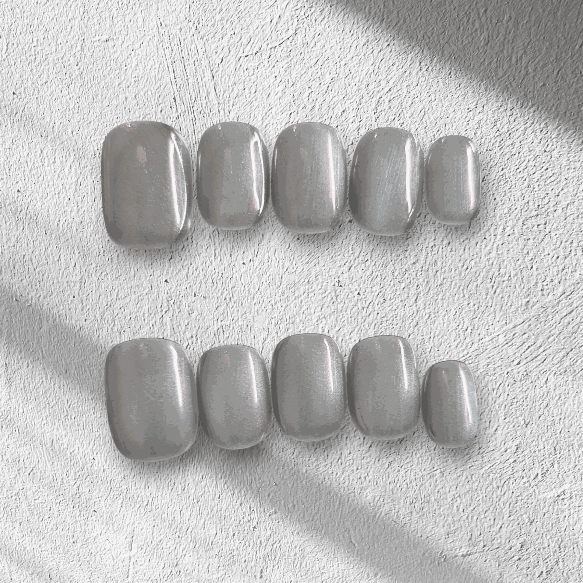 Lujain pearlescent gray-silver short oval press-on nail set displayed in the box.