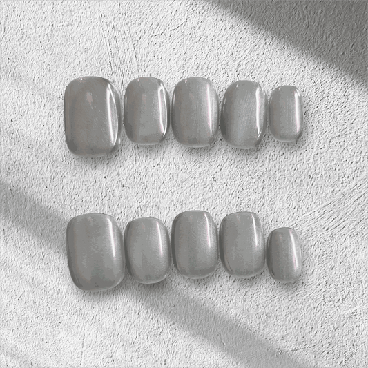 Lujain pearlescent gray-silver short oval press-on nail set displayed in the box.