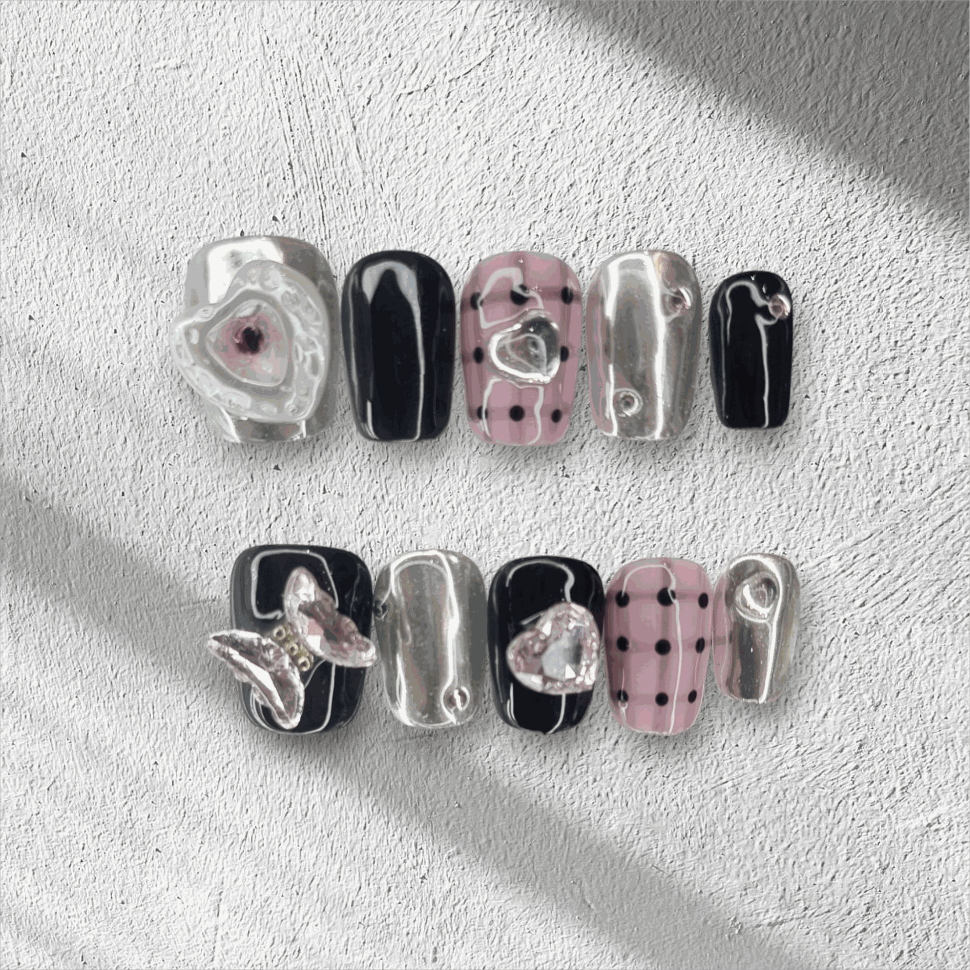 Maysoon black, pink, and silver coffin press-on nails by Nail Addict, featuring butterfly and heart charms.