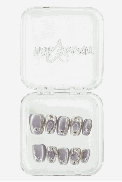 The minimalist Diriyah Elegance press-on nail set, displayed in its clear, branded Nail Addict case.