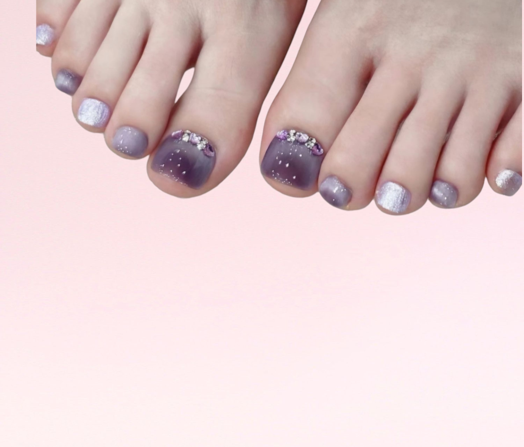 Detailed close-up of a pedicure featuring the glossy pink Mirfa pedi press-on toe nails.