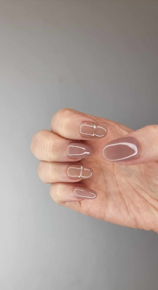 Close-up of a hand showcasing almond-shaped Munira nails painted in a matte finish.