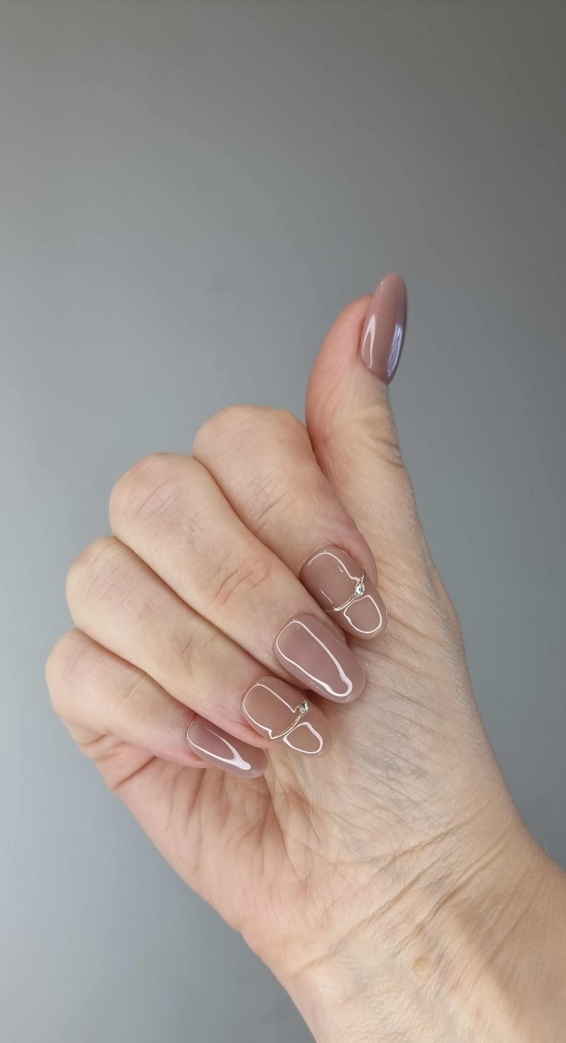 A hand with almond-shaped Munira nails painted in a matte finish.