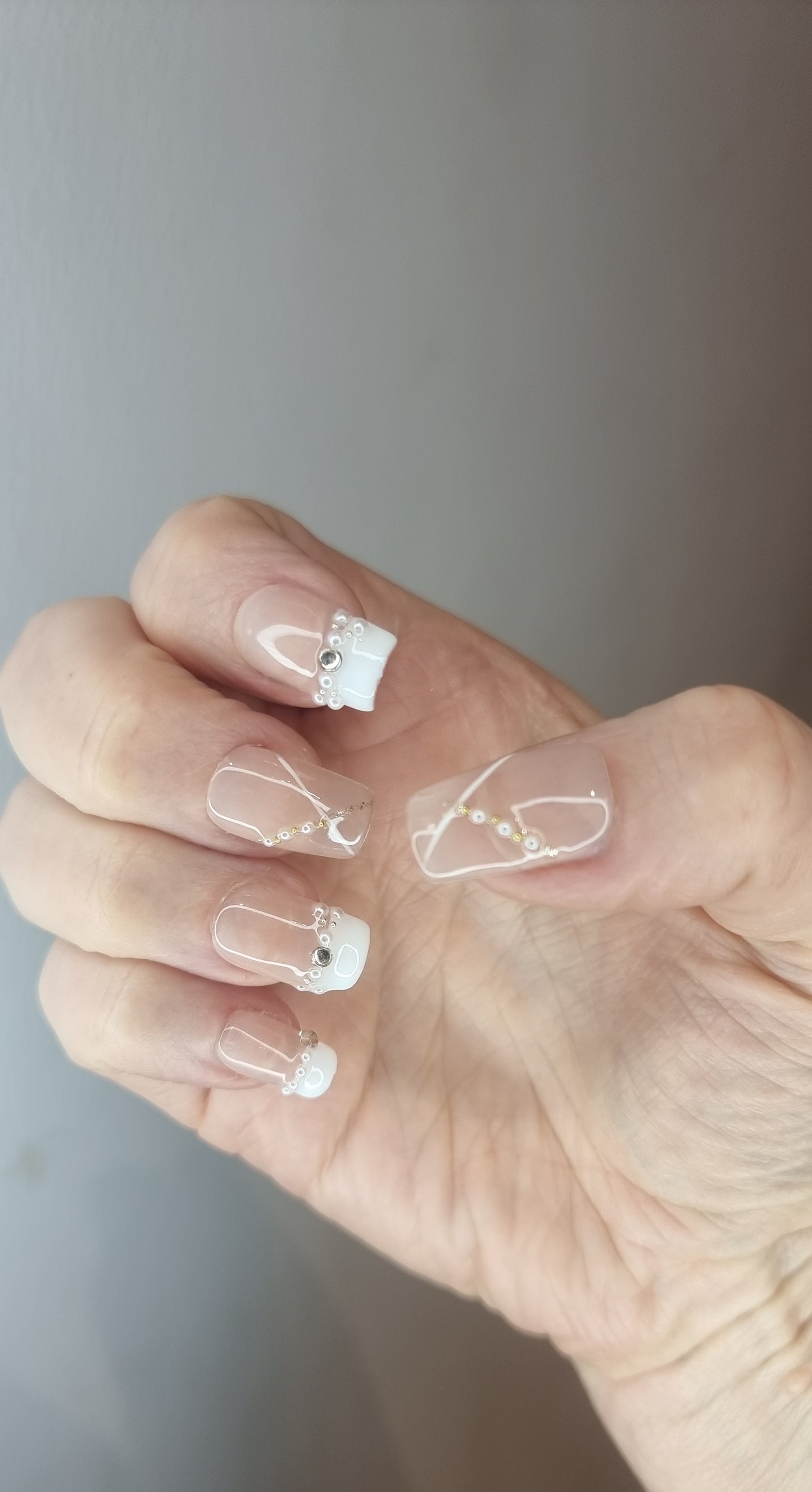 Hand wearing Nada pink French tip long coffin press-on nails.